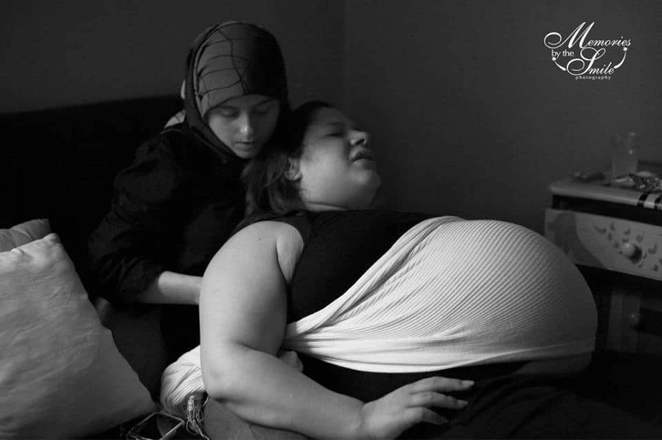 Doula turned web designer Nikki Shaheed supports a birthing mother with a rebozo