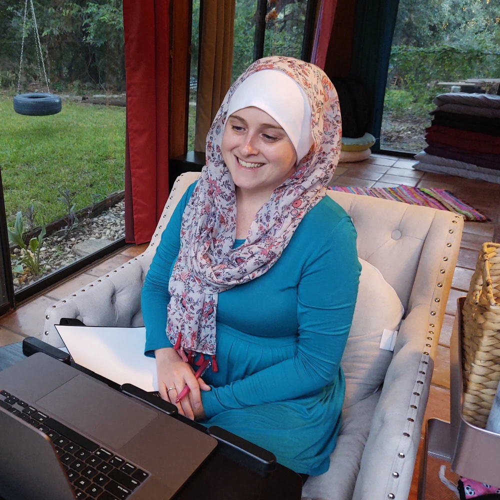 Nikki Shaheed smiles at the computer during a web design Zoom meeting with a small business owner