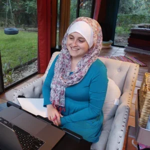 Nikki Shaheed smiles at the computer during a web design Zoom meeting with a small business owner